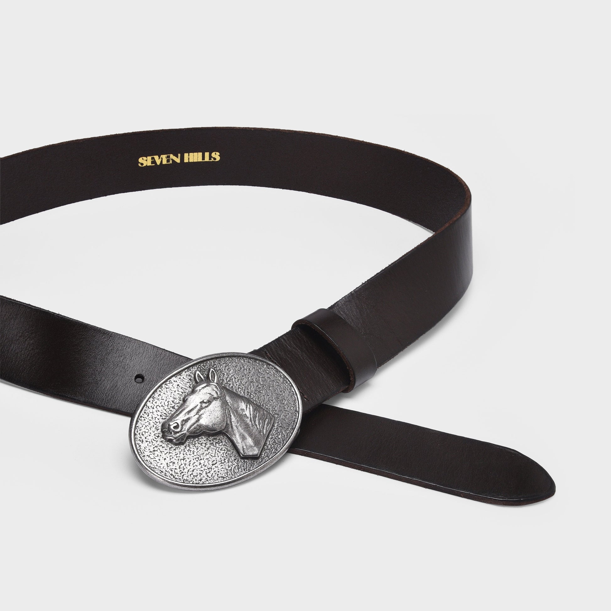 Black belt with a silver horse head buckle on a light gray background